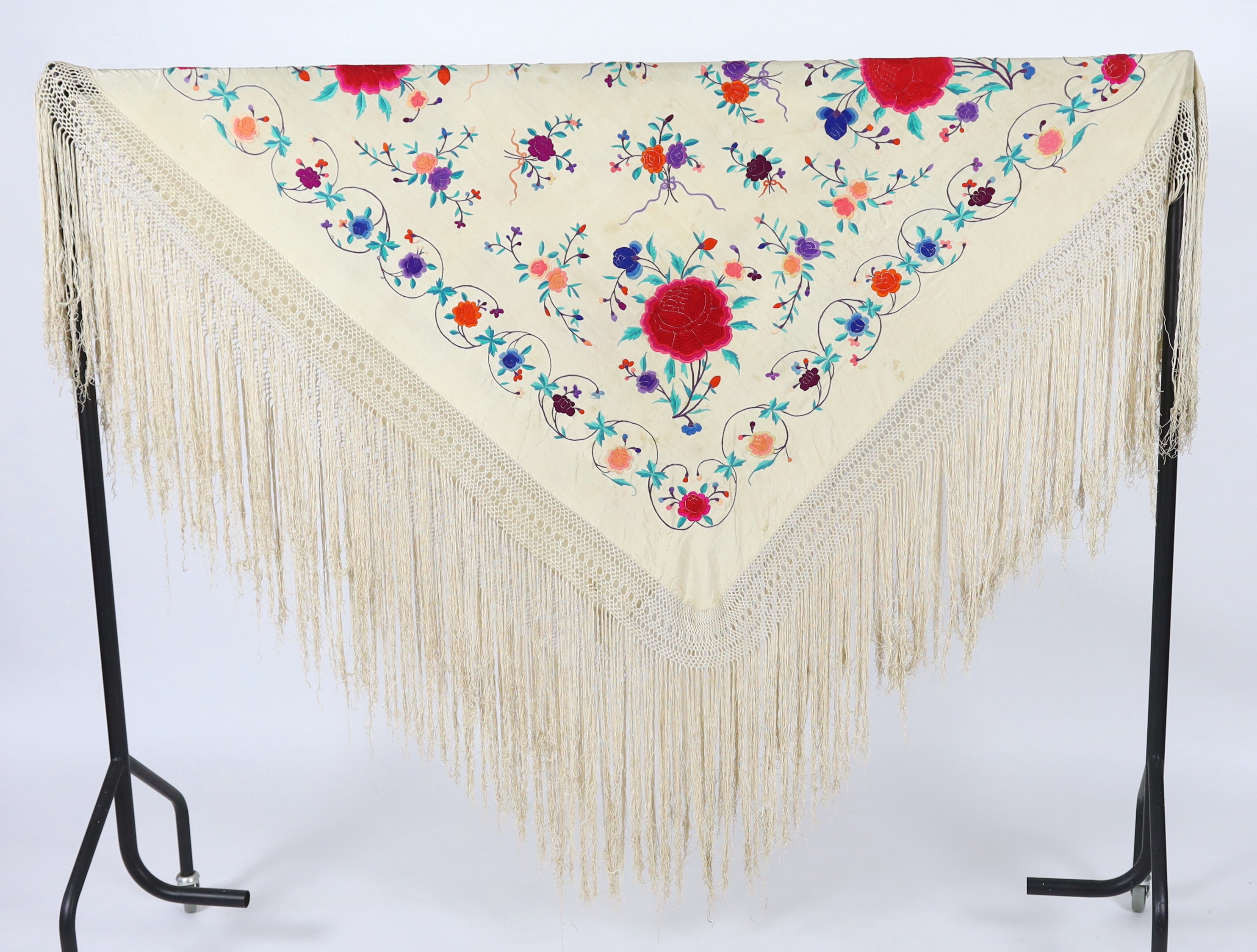 A late 19th / early 20th century cream silk fringed shawl, embroidered with all over polychrome silk floral motifs, 130 x 150cm not including fringe